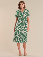 Woman wearing a green floral dress on a beige background