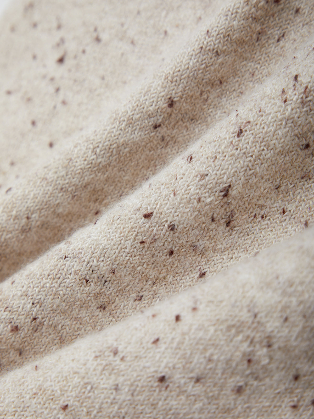 Close-up of beige fabric with brown specks