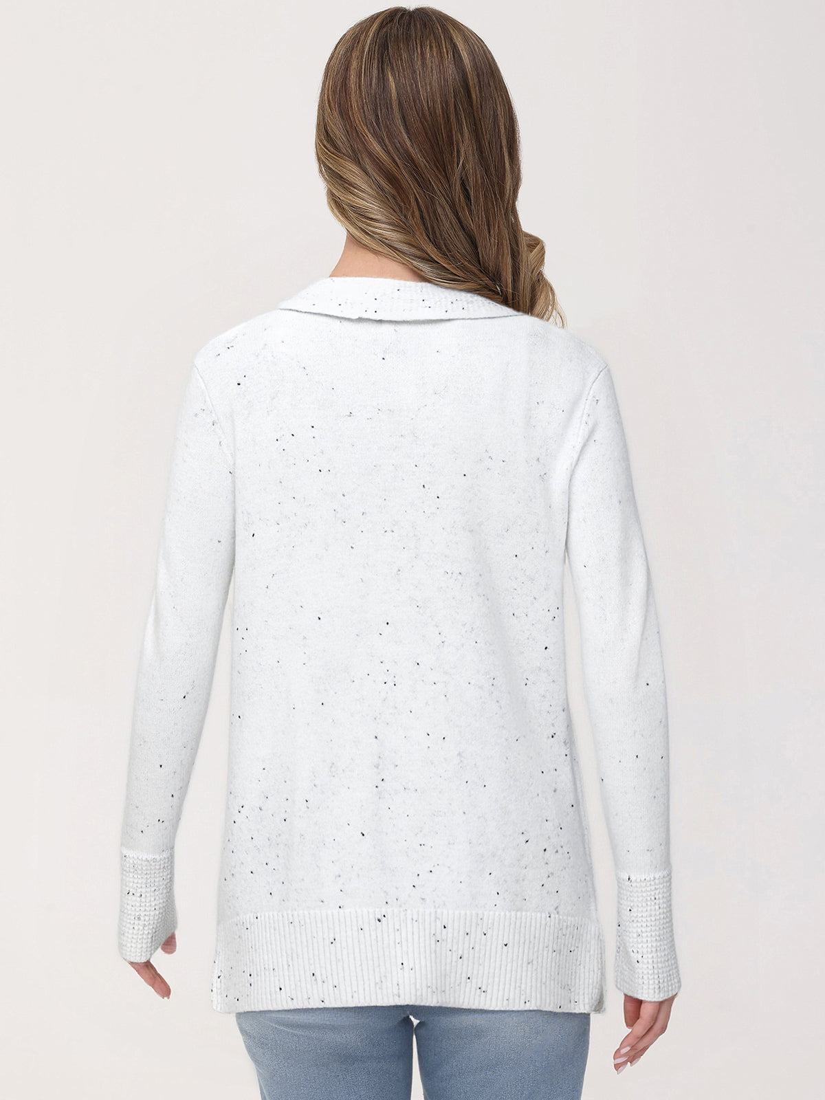 Woman wearing a light blue cardigan with a subtle pattern on a plain background