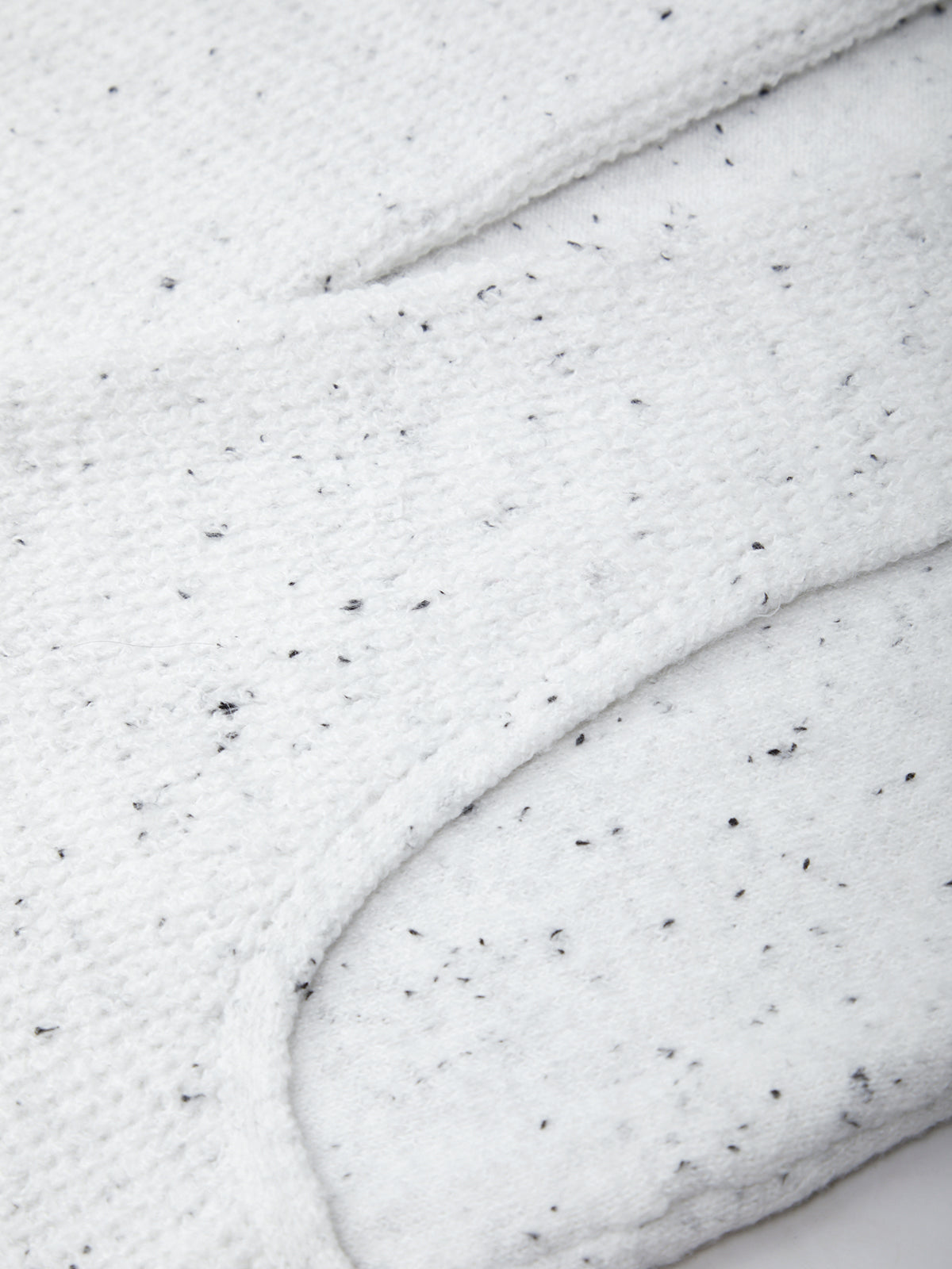Close-up of white frosting with black specks on a marble surface