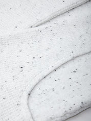 Close-up of white frosting with black specks on a marble surface