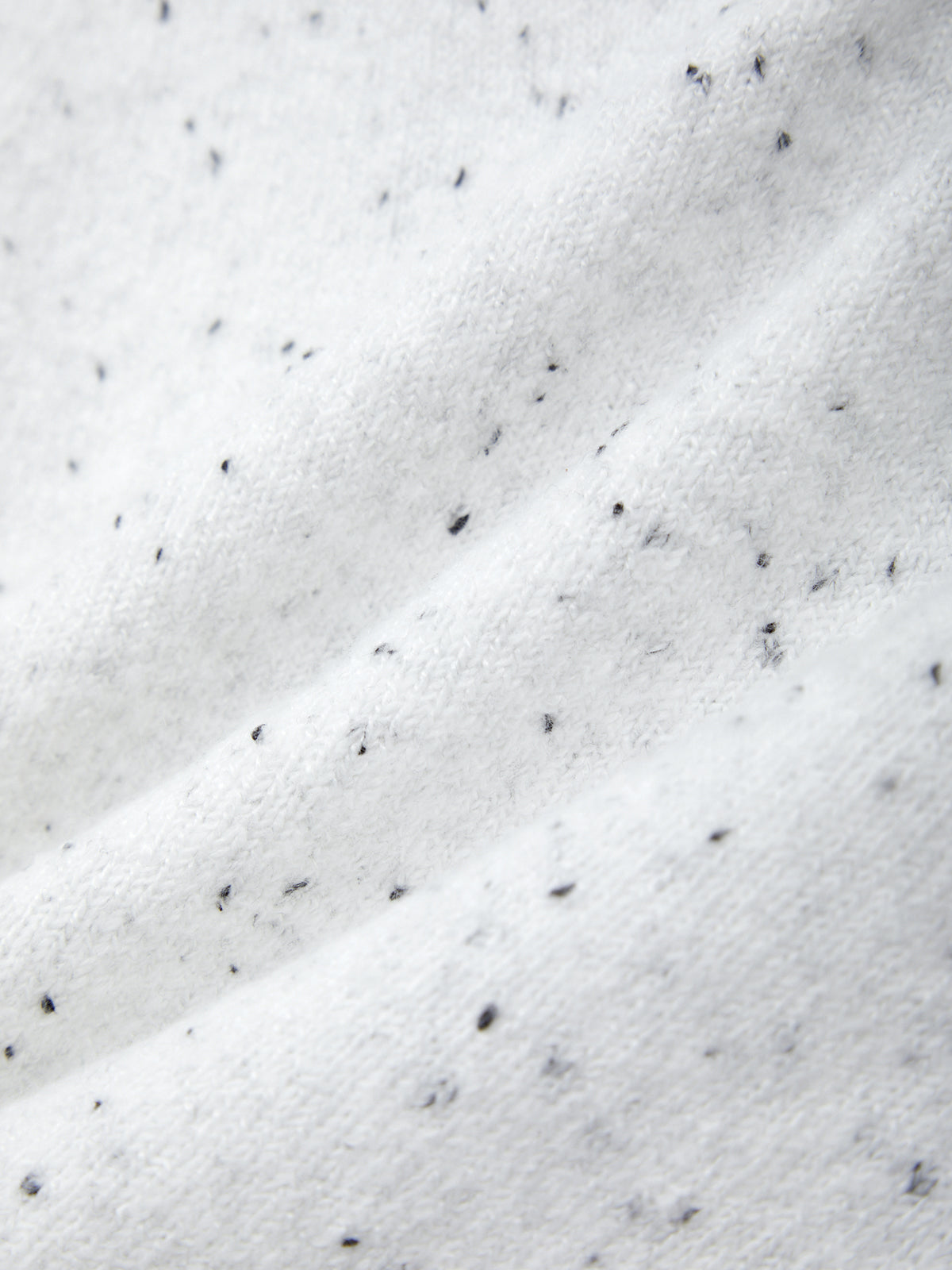 Close-up of white fabric with black specks