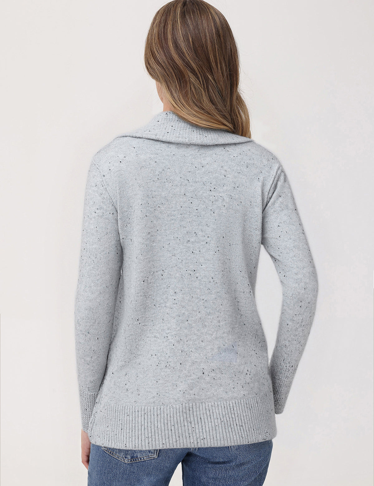 Person wearing a light gray knitted cardigan on a white background