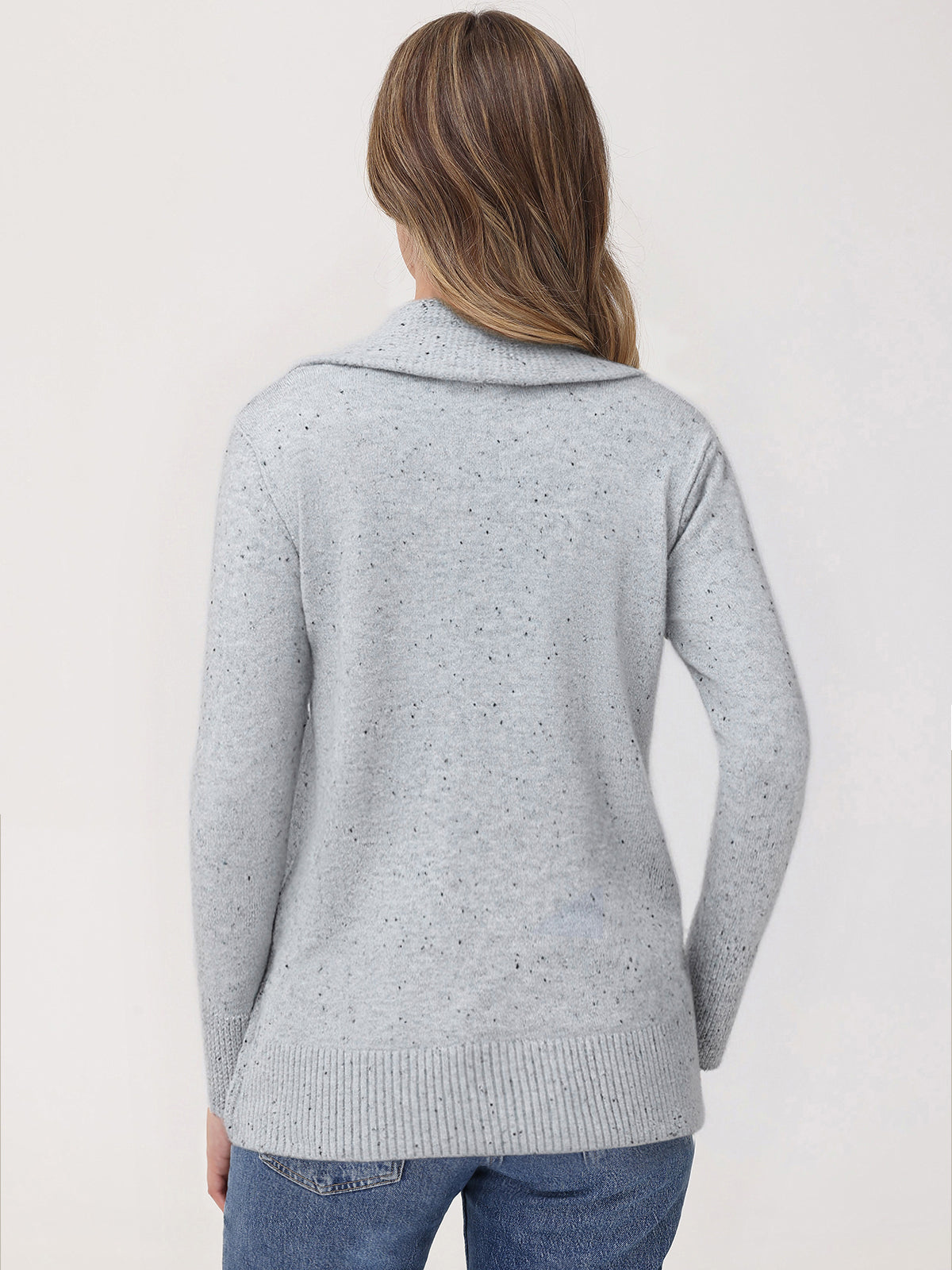 Person wearing a light gray knitted cardigan on a white background