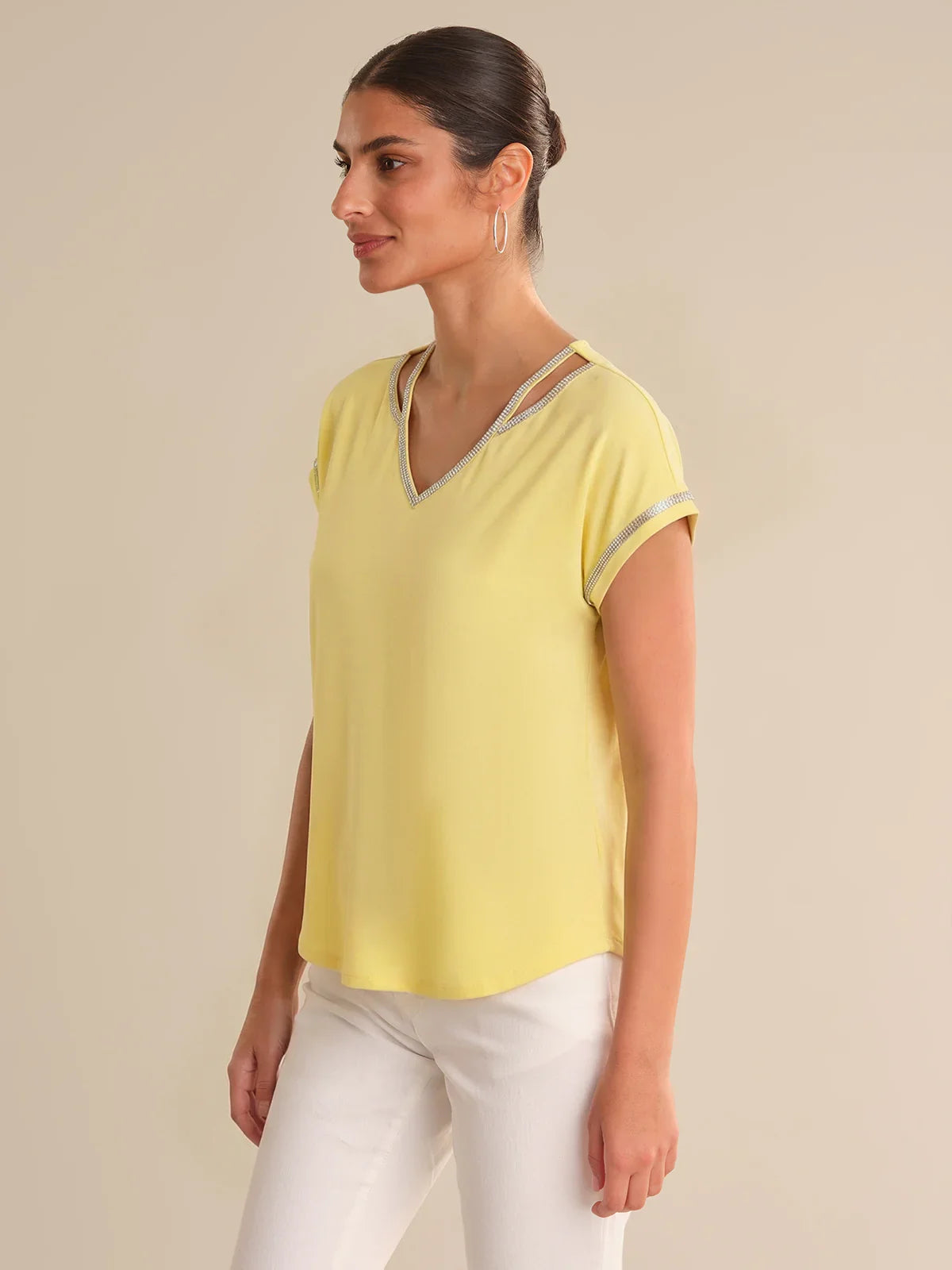 Woman wearing a yellow top with a beige background