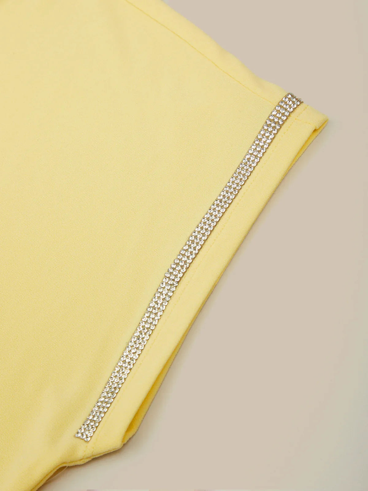 Yellow fabric with a decorative silver trim on a beige background