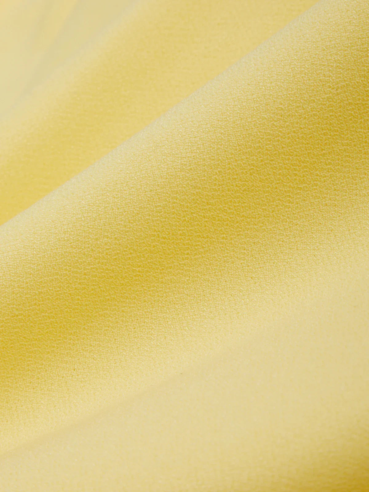 Close-up of yellow fabric with a subtle texture