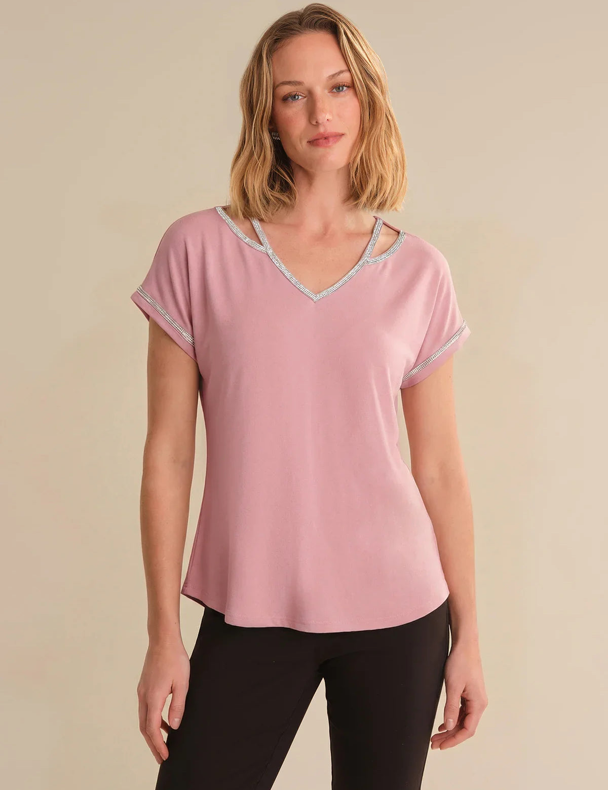 Woman wearing a pink t-shirt with a beige background