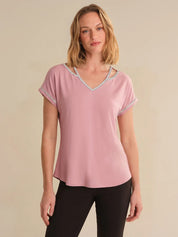 Woman wearing a pink t-shirt with a beige background