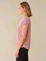 Woman wearing a pink t-shirt against a beige background