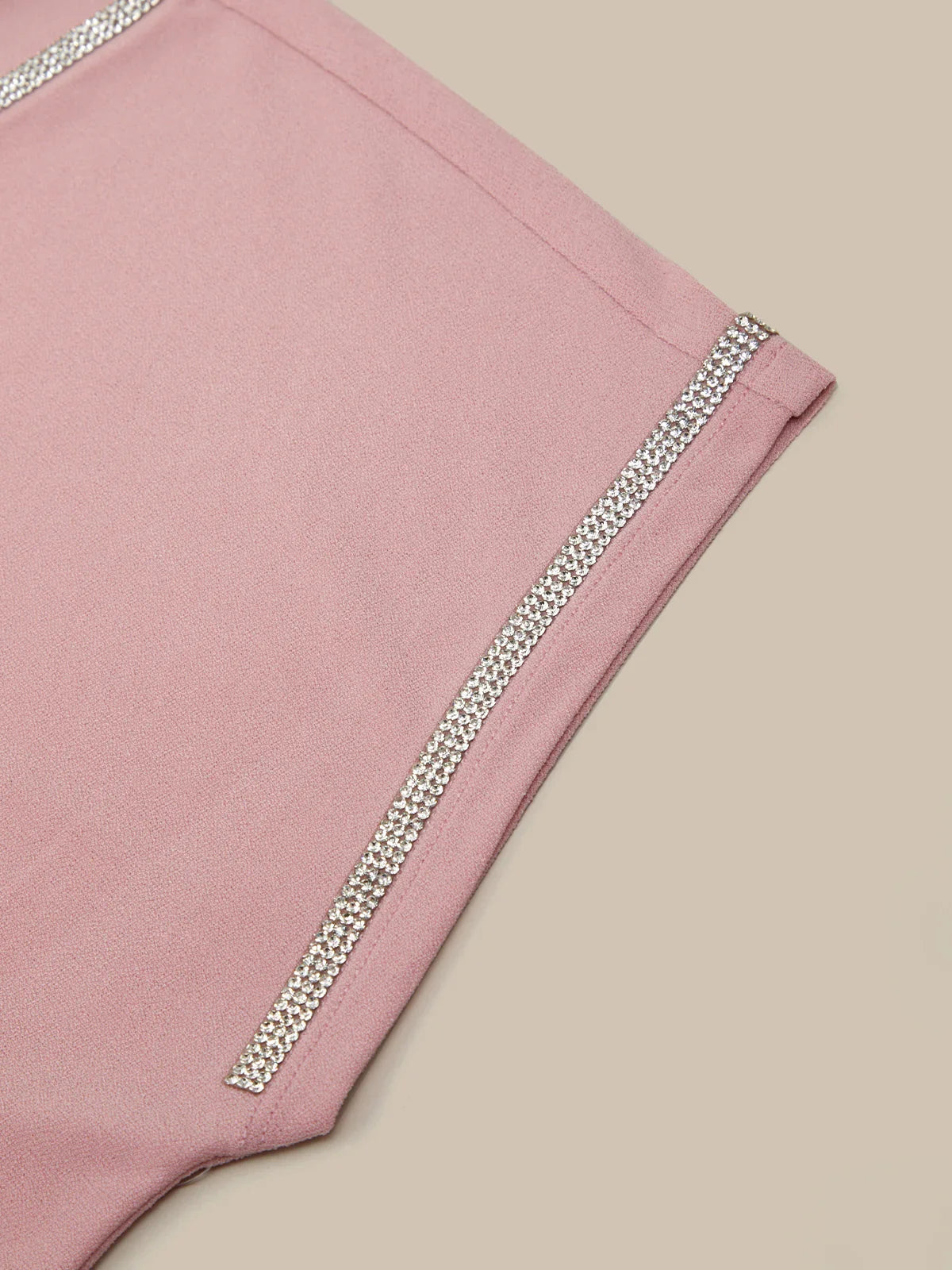 Pink shorts with silver trim on a beige background