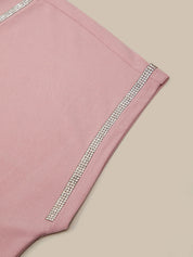 Pink shorts with silver trim on a beige background