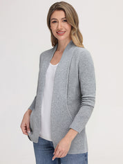 Woman wearing a gray cardigan over a white top and blue jeans on a white background