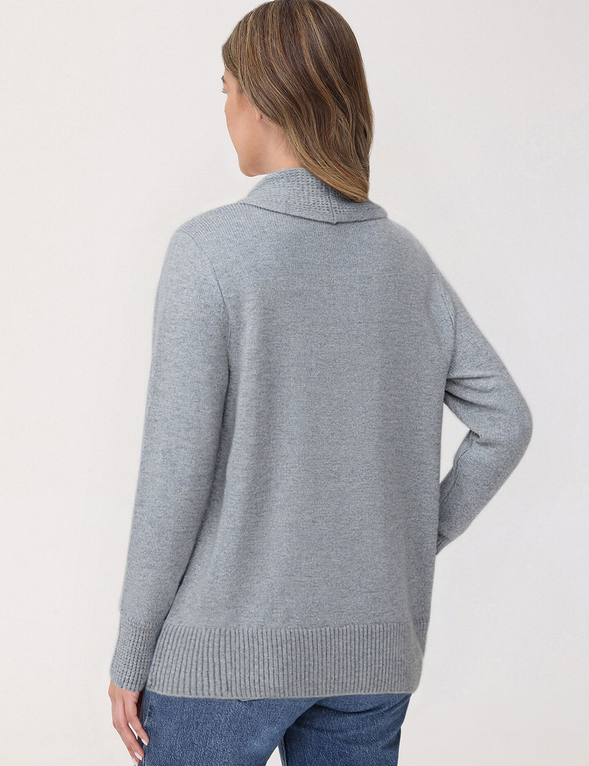 Woman wearing a gray sweater against a white background