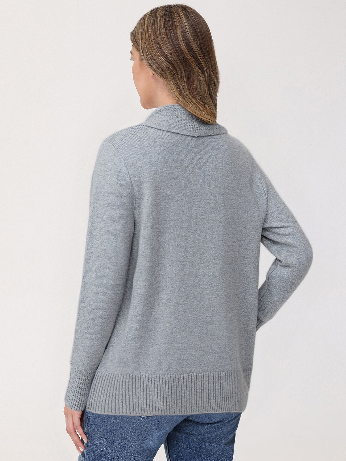 Woman wearing a gray sweater against a white background