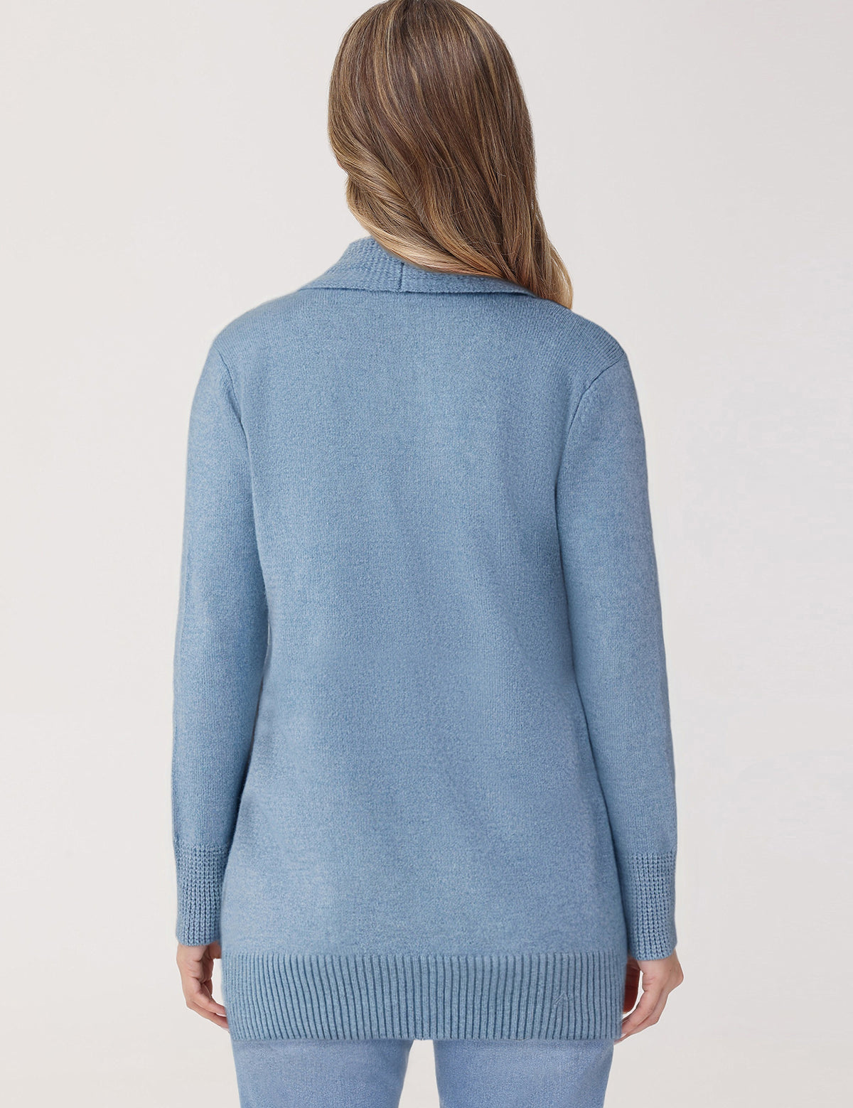 Person wearing a light blue sweater on a plain background