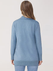 Person wearing a light blue sweater on a plain background