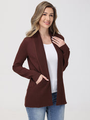 Woman wearing a brown cardigan over a white shirt and blue jeans on a white background