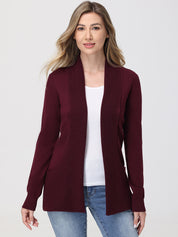 Woman wearing a burgundy cardigan over a white shirt and blue jeans on a plain background