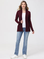 Woman wearing a burgundy cardigan, white shirt, blue jeans, and white sneakers on a white background