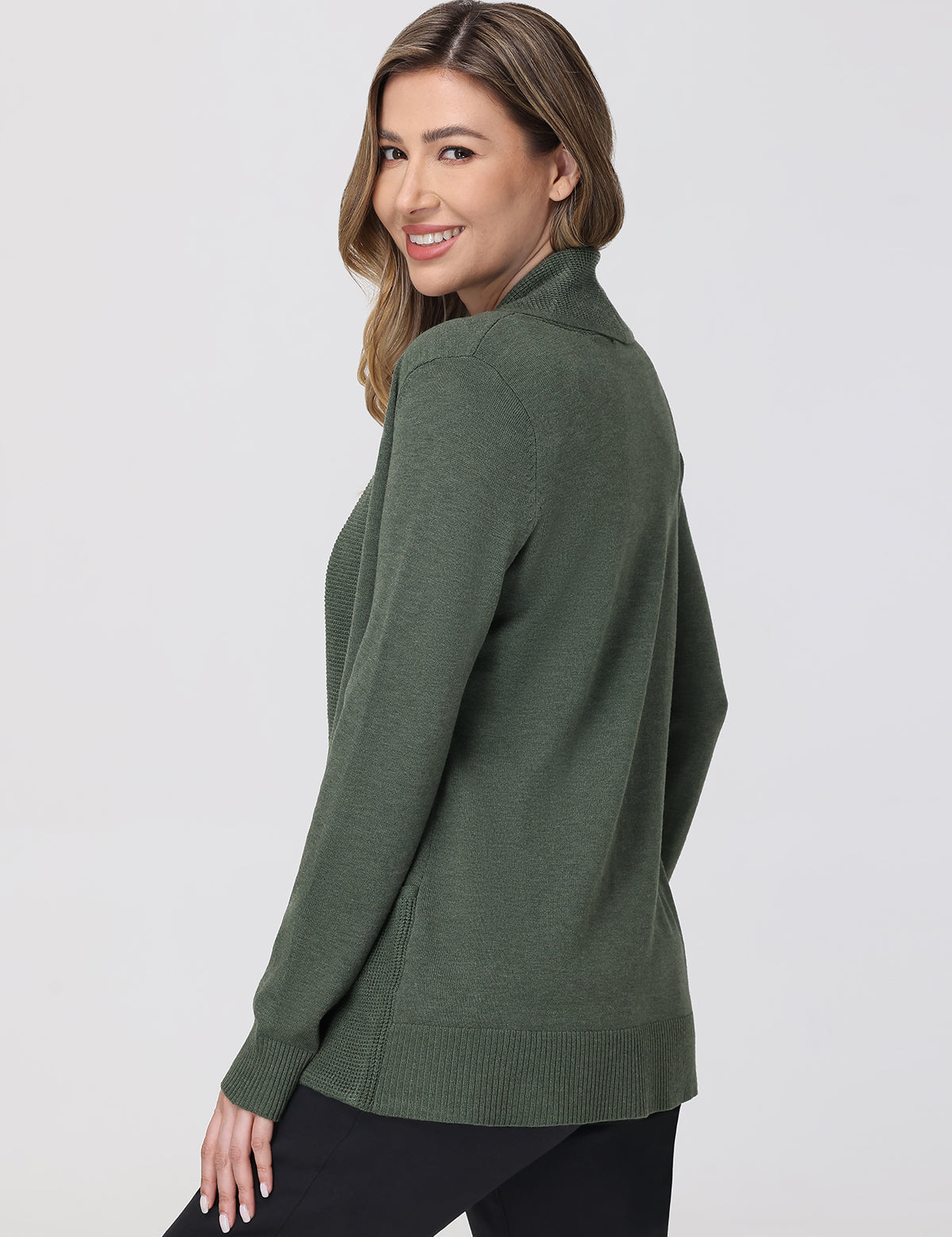 Woman wearing a green sweater against a white background