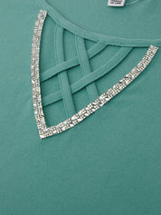 Teal dress with a decorative silver trim on a green background