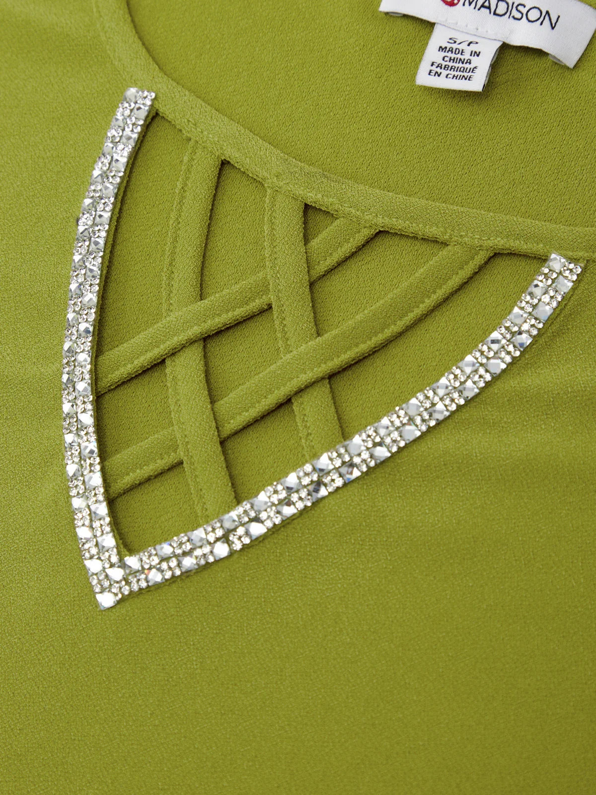 Green dress with decorative lattice and rhinestone trim, brand label visible.