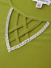 Green dress with decorative lattice and rhinestone trim, brand label visible.