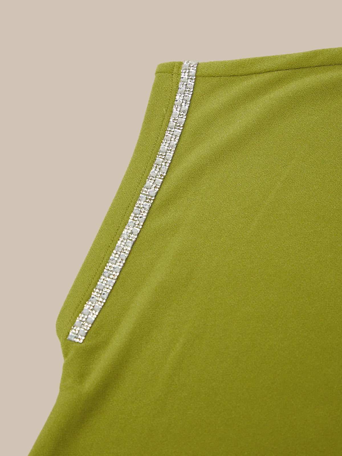 Green garment with a decorative silver trim on a beige background