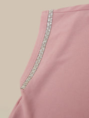 Pink garment with a decorative silver trim on a beige background