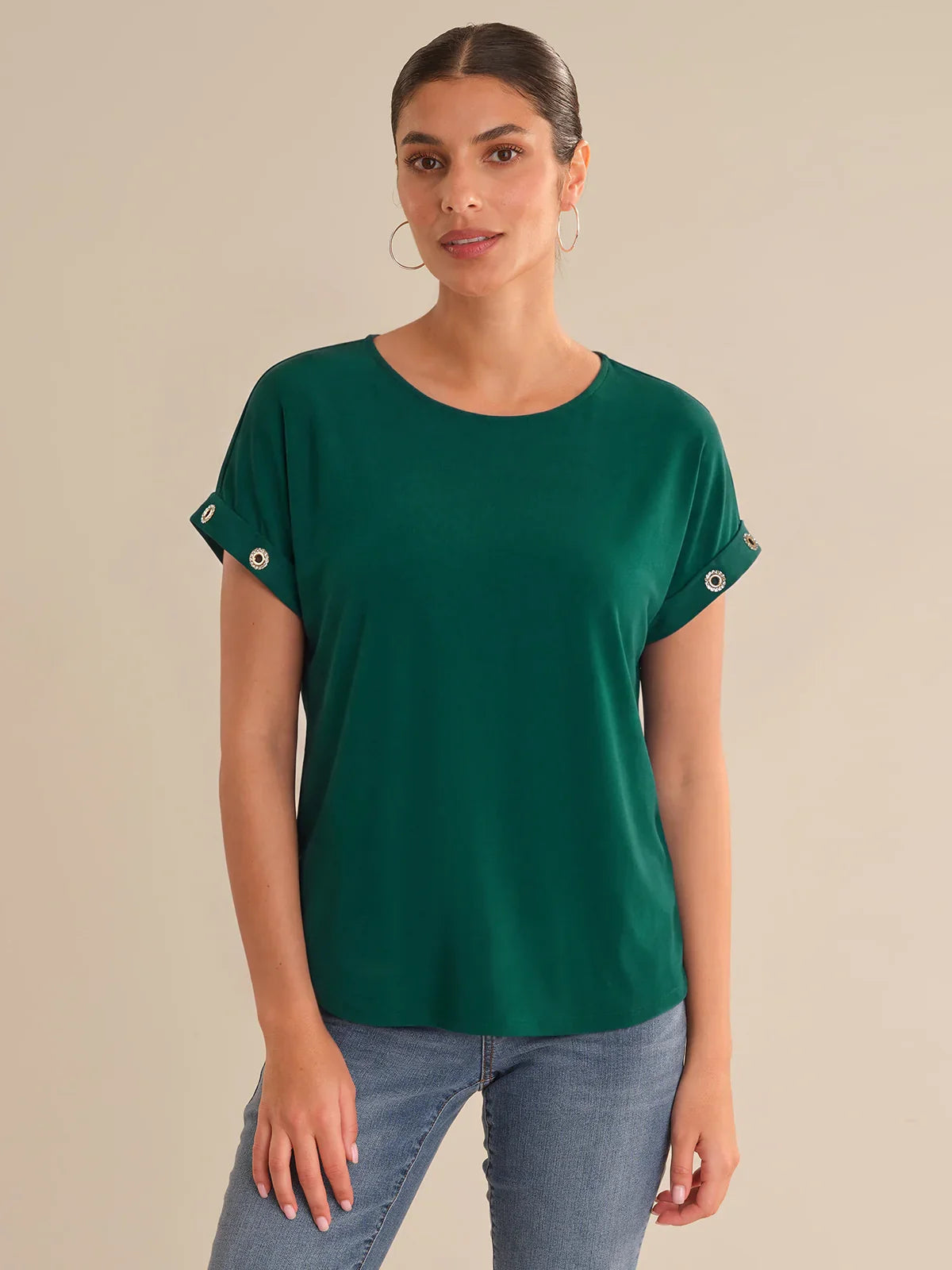 Woman wearing a green top against a beige background