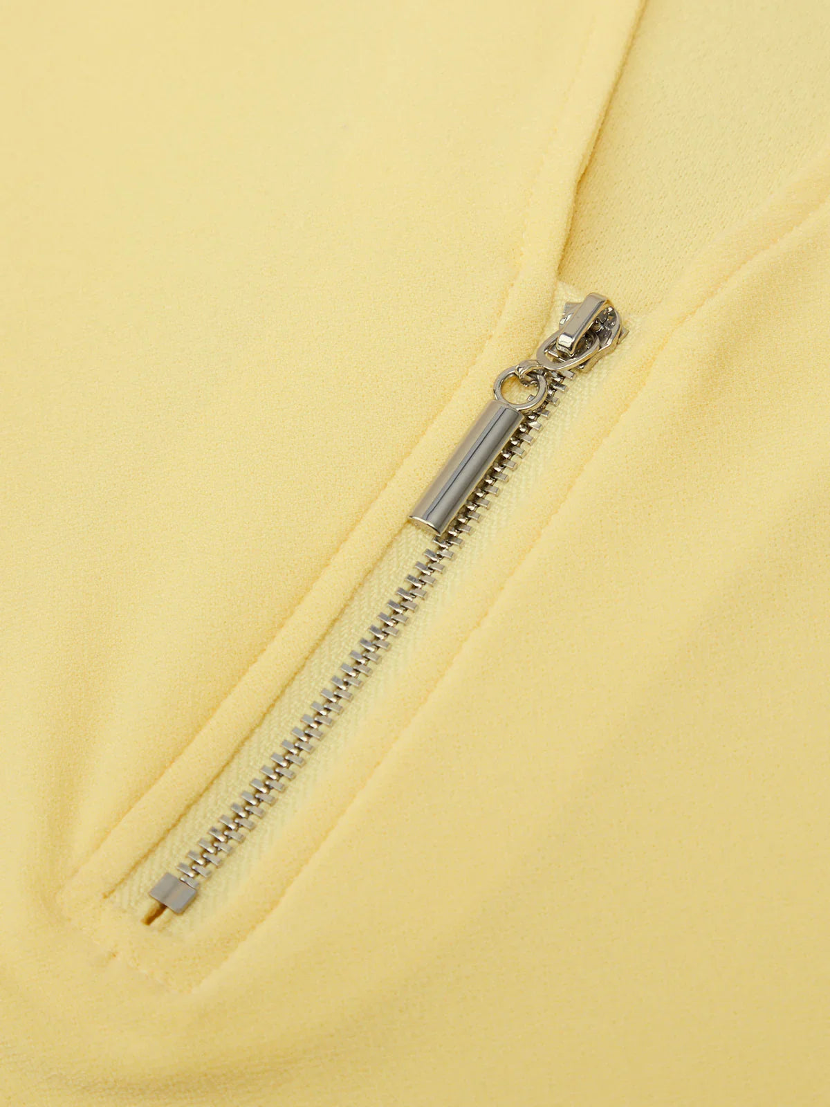 Close-up of a zipper on a yellow garment