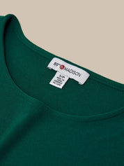 Green garment with a label on a beige background