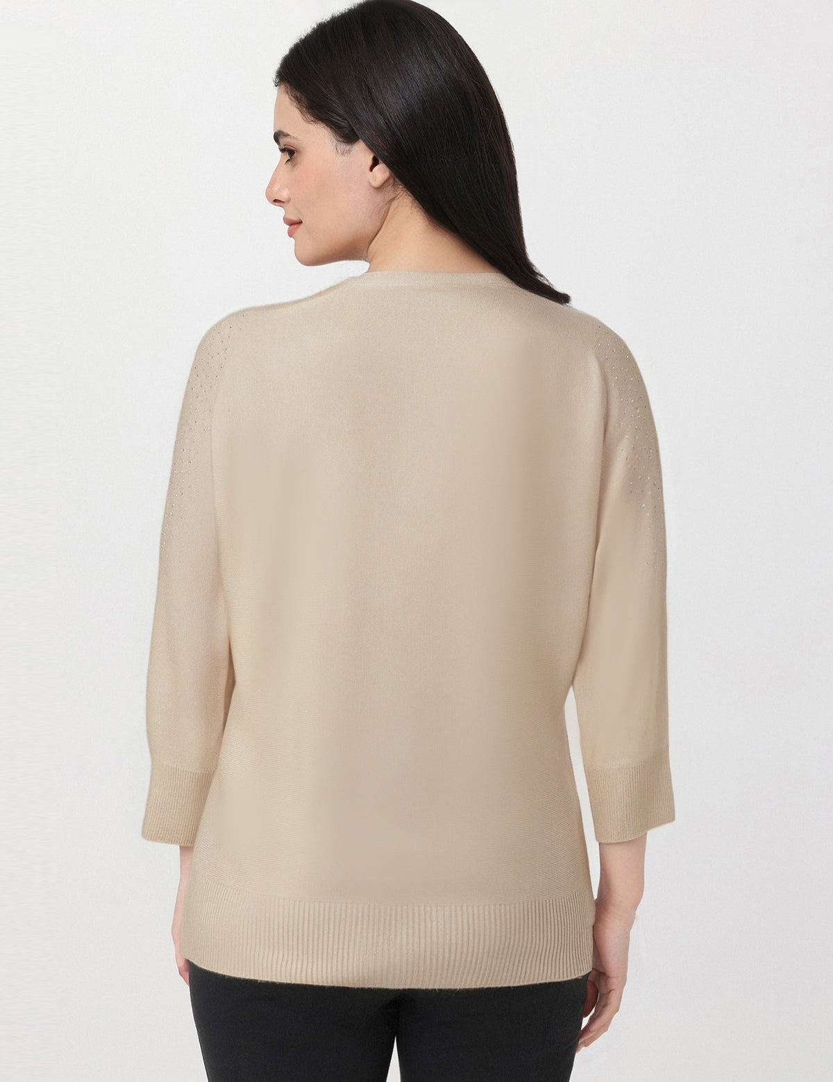 Woman wearing a beige sweater on a white background