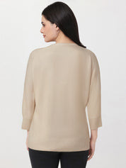 Woman wearing a beige sweater on a white background