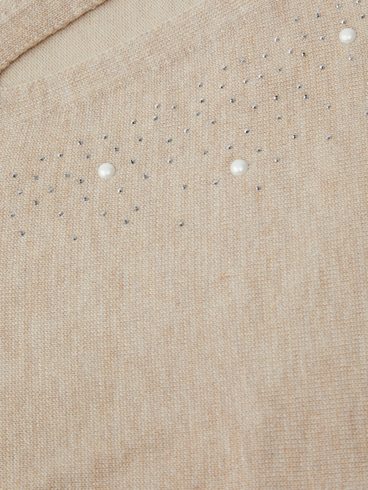 Close-up of beige fabric with small white pearls embedded