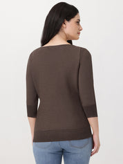 Woman wearing a brown sweater and blue jeans on a white background