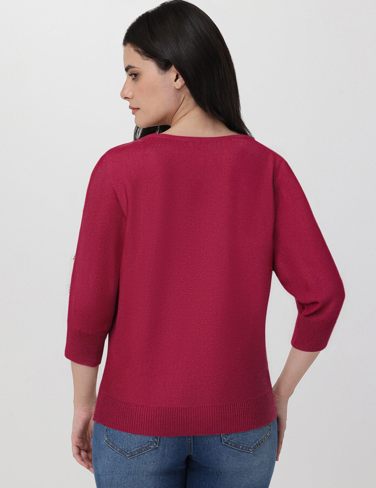 Woman wearing a red sweater and blue jeans on a white background