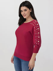 Woman wearing a red sweater with grommet sleeves on a white background