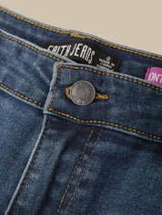 Close-up of a pair of blue denim jeans showing the waistband, button closure, and inner label reading FAITHJEANS.