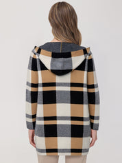 Person wearing a checkered hoodie with a neutral background