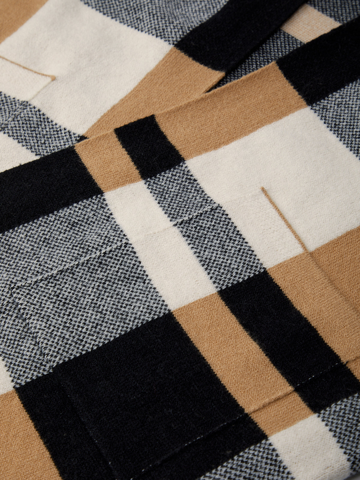 Close-up of a checkered fabric with brown, black, and white patterns.