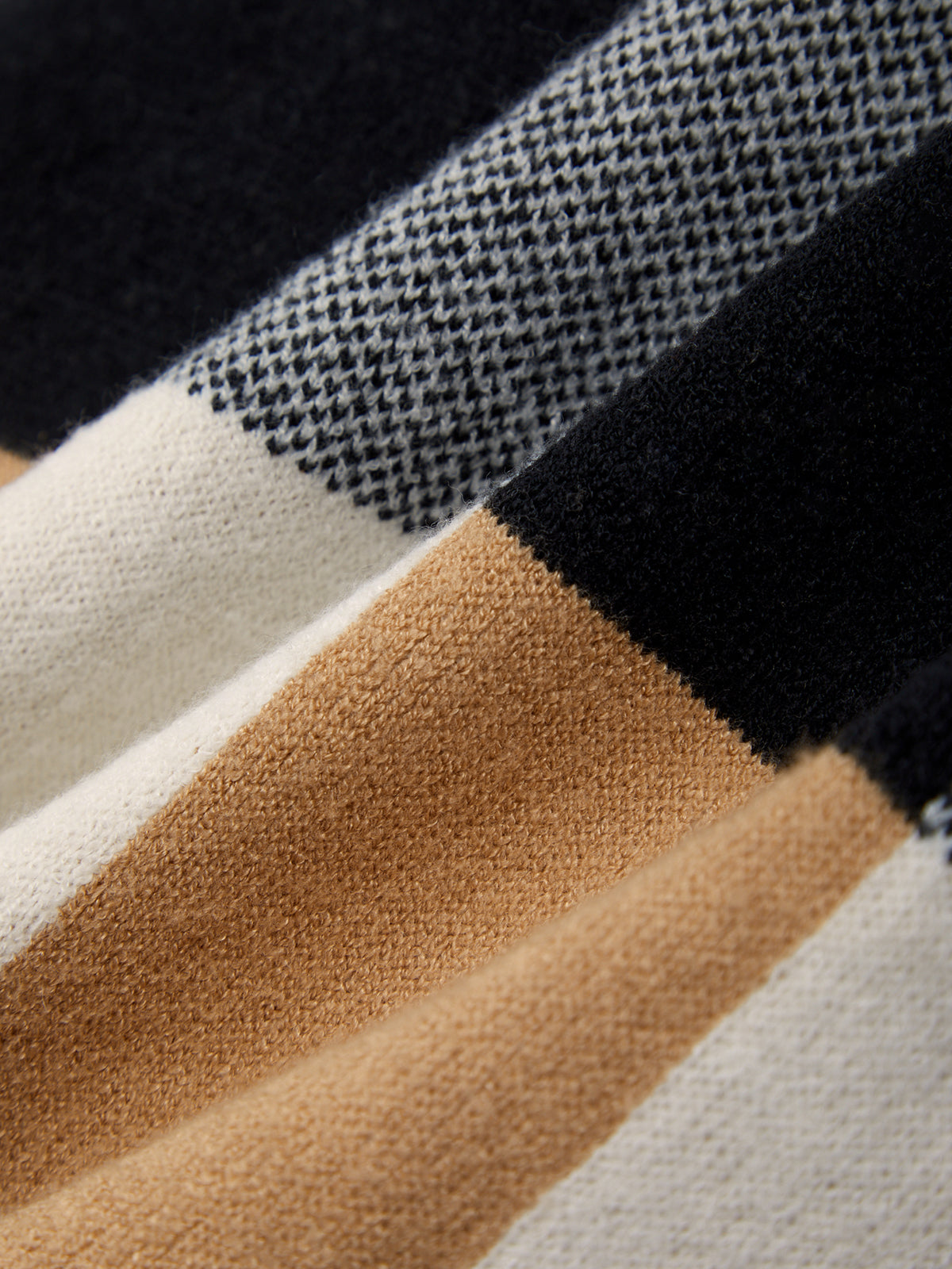 Close-up of fabric with black, white, brown, and beige stripes.