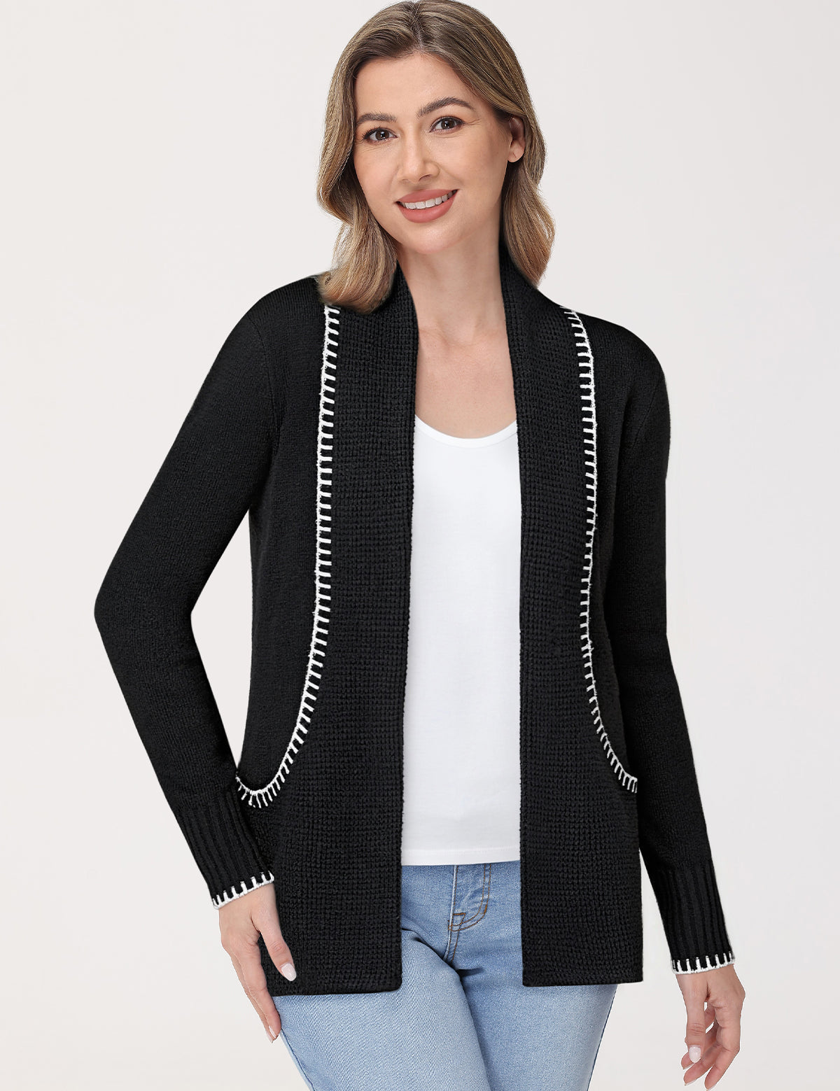 Woman wearing a black cardigan with white trim on a white background