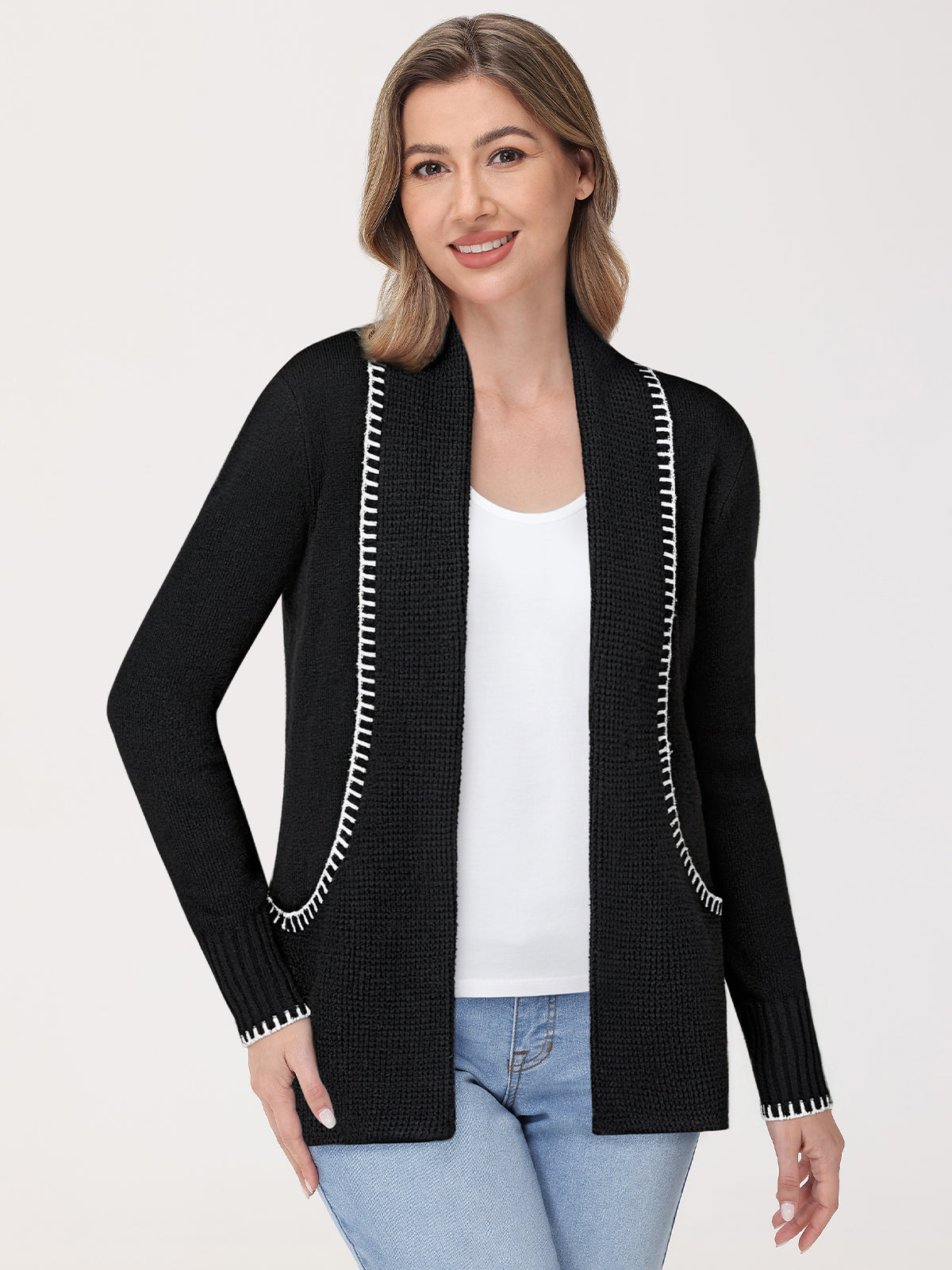 Woman wearing a black cardigan with white trim on a white background