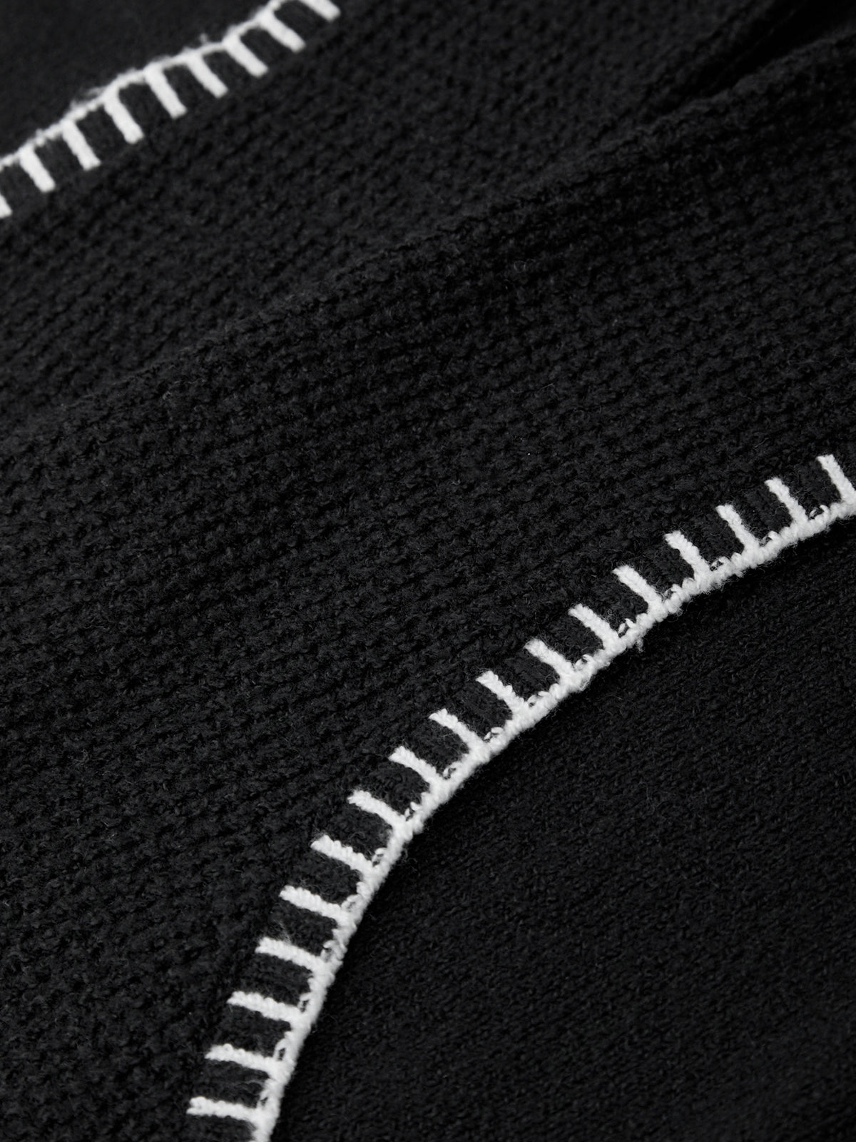 Close-up of black fabric with white stitching detail