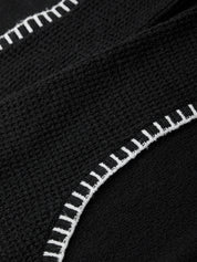 Close-up of black fabric with white stitching detail