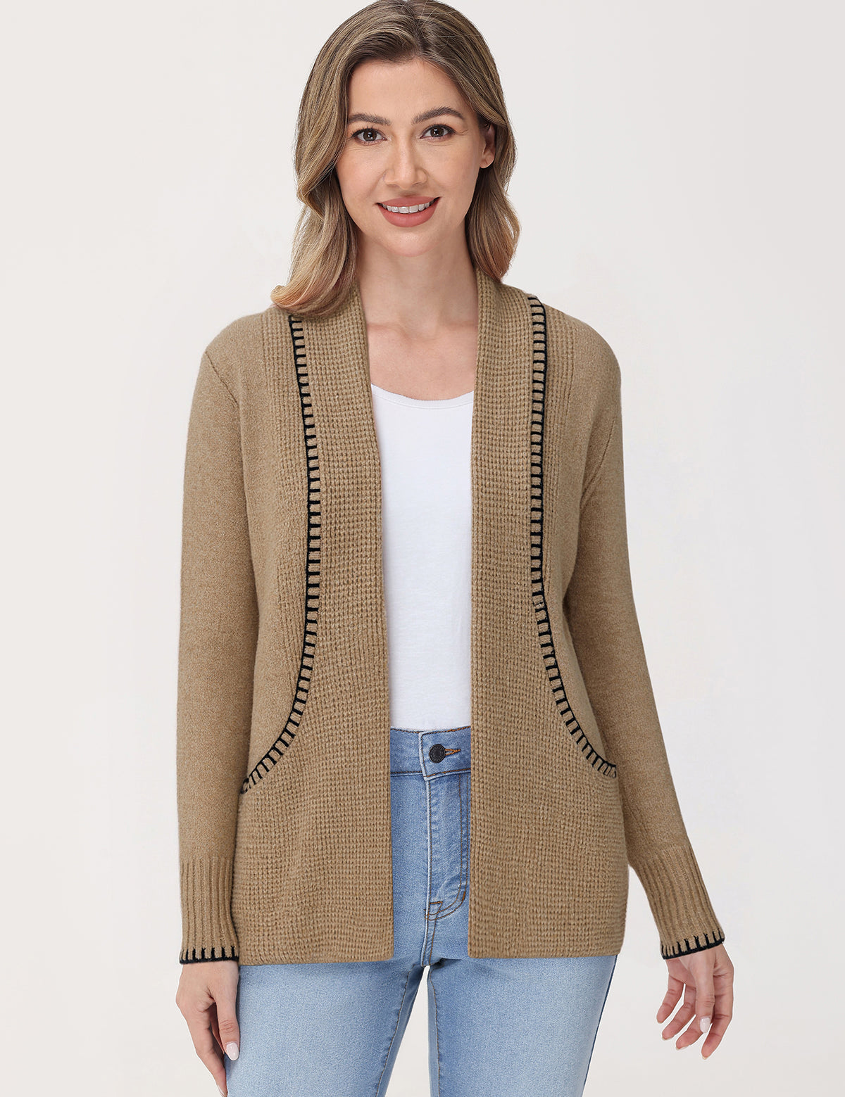 Woman wearing a beige cardigan with black trim on a white background