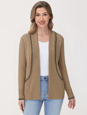 Woman wearing a beige cardigan with black trim on a white background