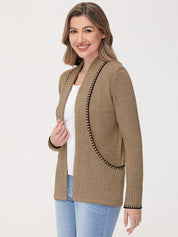 Woman wearing a beige cardigan with black trim on a white background